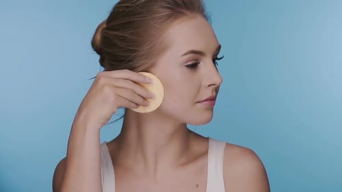 Woman Using Round Sponges for Cosmetic Skin Treatment