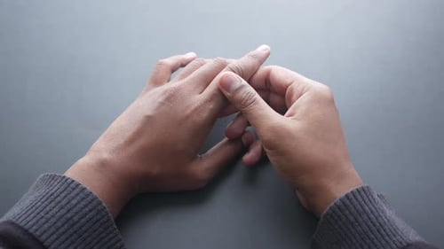 Man Suffering Pain in Finger on Black Background