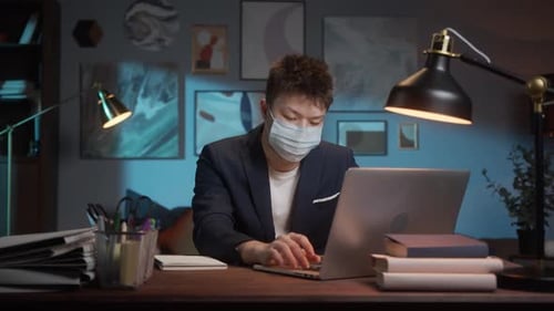 Young Adult Works at Home with Mask