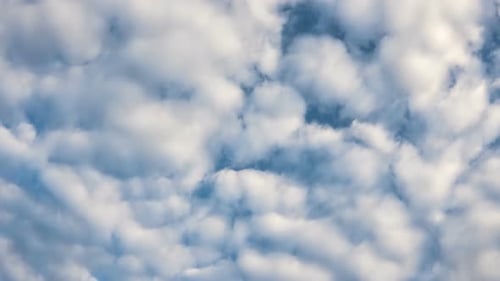 Billowing White Clouds Drifting Across the Blue Sky