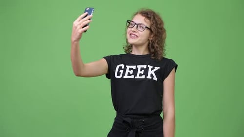 Smiling Young Adult Using Smartphone on Green Screen