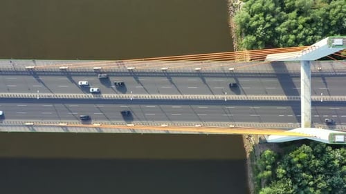 Aerial View of Traffic on highway road. Bridge over river. Dark water.