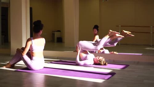 Two Women Exercising with Pilates Stretching Routine