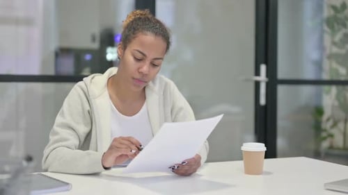 Woman Reacts Positively to Paperwork in Office