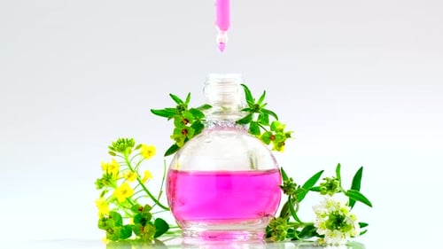 Perfumaria. Produto de óleo essencial. Gotas caindo da pipeta cosmética para o frasco de vidro com perfume