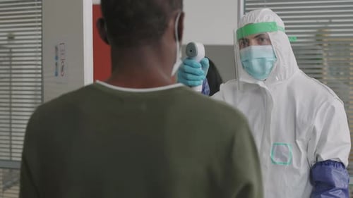 Worker Checking Temperature at Office Entrance