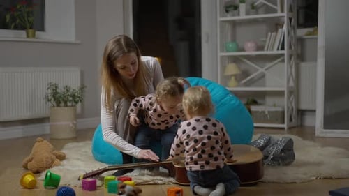 Woman and Two Children Playing Together Indoors