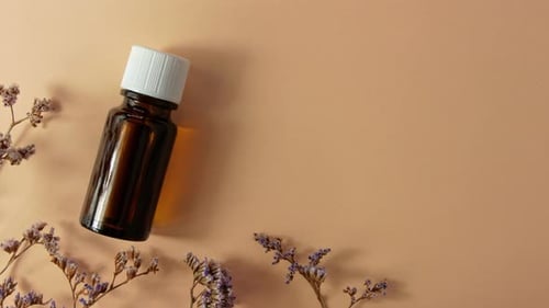 Herbal essential oil glass bottle mockup beige flowers background Spa aromatherapy beauty cosmetics