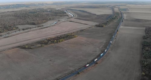 Aerial View Of Large Trucks Driving On The Asphalt