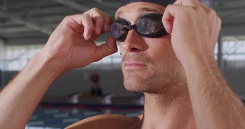 Swimmer putting his pool goggles