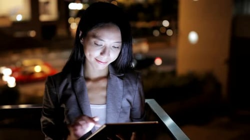 Woman Using Tablet at Night in City