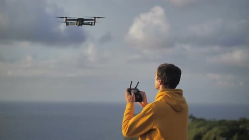 Young Adult Operating Drone on Tropical Island Coastline