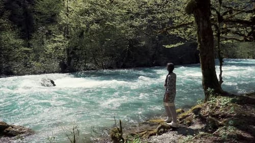 Alleine junge Frau genießt die ruhige Waldlandschaft in der Nähe des Flusses
