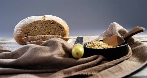 Loaf of Bread with Knife and Bowl of Grains