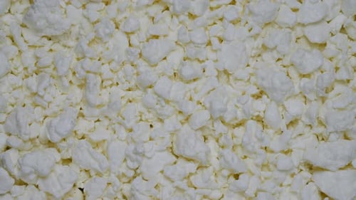 Cottage cheese as background, rotating on a table.
