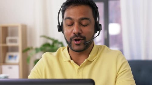 Young Adult with Headset Talking on Laptop