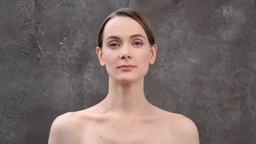 Close-Up Portrait of a Woman Against Gray Backdrop
