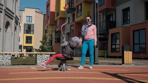 Little Girl with Mother Having Fun on Playground