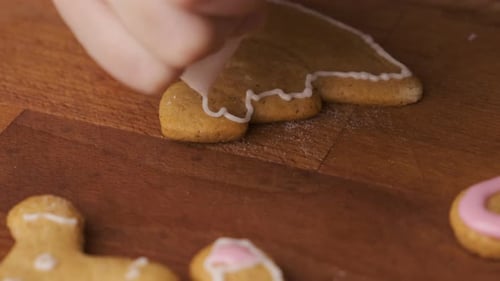 Decorating Gingerbread Cookies in the Shape of Christmas Tree with Royal Icing