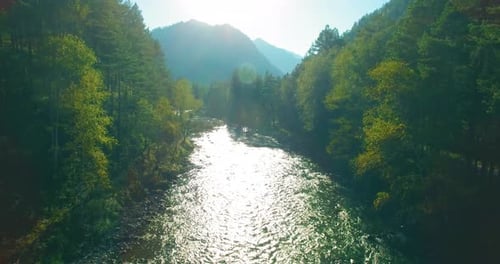 Flug in geringer Höhe über den frischen Fast Mountain River mit Felsen am sonnigen Sommermorgen.