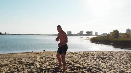 Bare Chested Man Boxing on a Sunny Beach