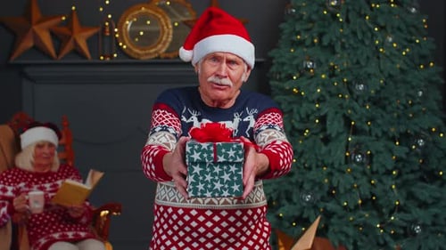 Cheerful Senior Man Presents Christmas Gift