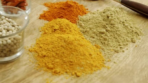 Colorful Spices and Herbs Arranged on Wooden Board