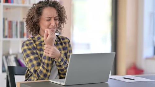 Woman Experiences Wrist Pain While Working on Laptop