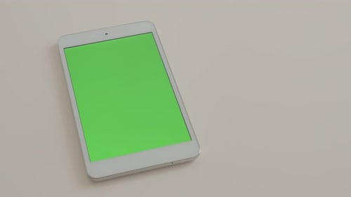 Tablet-pc with green screen display on white reflective background 4K 2160p UltraHD footage - Green