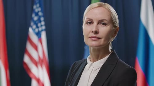 Professional Woman Standing in Front of Flags