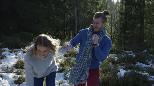 Jeune couple jouant avec la neige