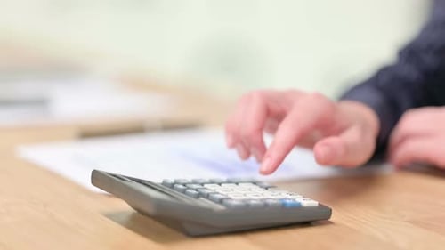 Close Up of Male Hand Using Calculator