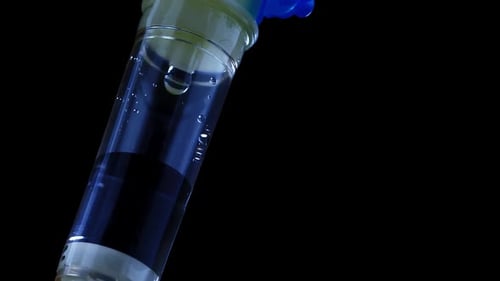 Medical Dropper Close Up in the Light of a Special Signal of a Police Car