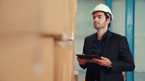 Factory Manager Using Tablet Computer in Warehouse or Factory