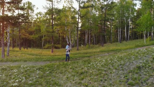 Young Couple Walking on a Mountain Path. Woman Piggyback Ride Boyfriend