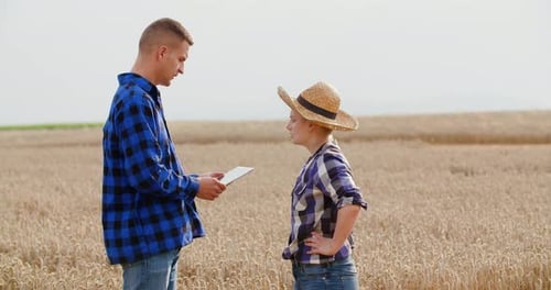Female Farmer Discussing With Businessman On Farm