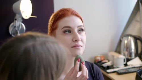 Woman Applies Makeup With Green Sponge Indoors