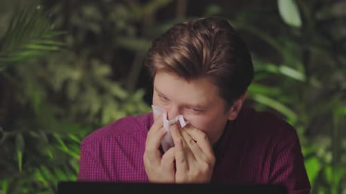 Man Blowing Nose with Tissue Close Up
