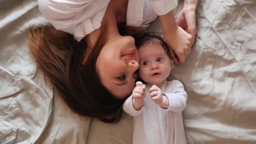 Mother with son lying in bed. Above view