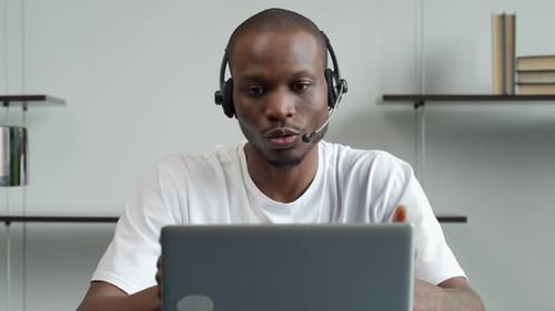 Professional Man Communicates Via Laptop With Headset