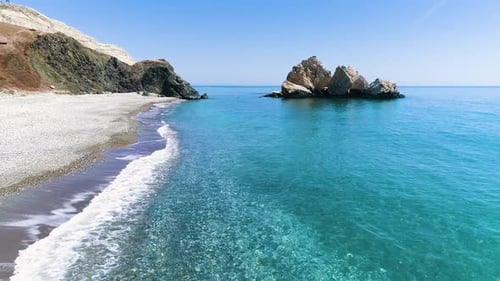 Aerial Top View of Waves Crash on the Beach in a Blue Ocean