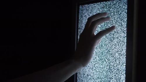 Human Hand Touching Old Retro Television Screen with Ripples Wavy Flowing Damaged Signal