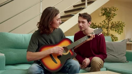 Men Playing Guitar and Singing on Couch