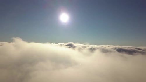 Aerial view from above of white puffy clouds.