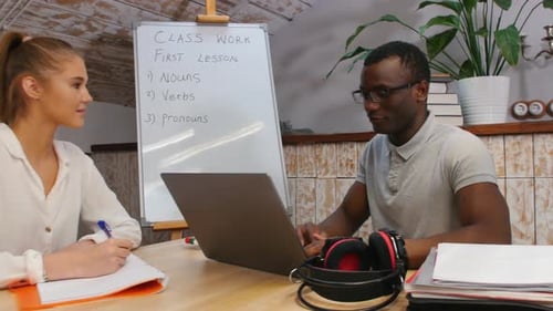 Cours d'anglais - une femme et un homme afro-américain ayant une leçon - un homme assis près de l'ordinateur portable et