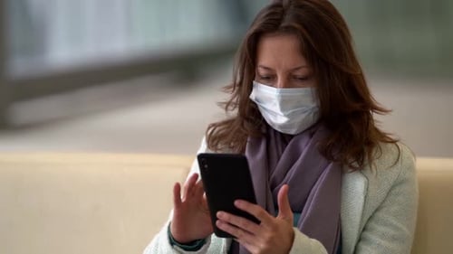 Adult Woman with Smartphone in Public Place, Wearing Surgical Face Mask for Protecting From Covid-19