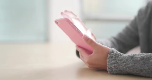 Hands Operate Mobile Phone on Table Indoors