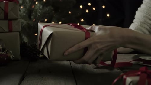 Woman Wrapping Christmas Present at Night