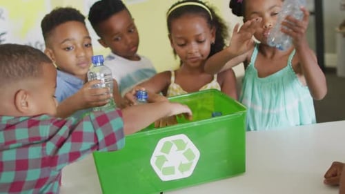 Children Recycling Plastic Water Bottles in Classroom
