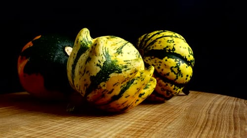 Colorful Gourds Rotating on a Wooden Surface